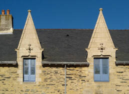 Lucarnes granit sur manoir ancien avec fenêtres à petits bois bleus